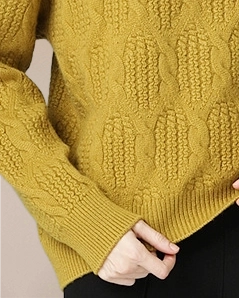 Detail of VIONIS·XY antique gold cashmere sweater sleeve, thick cable knit with soft structured feel