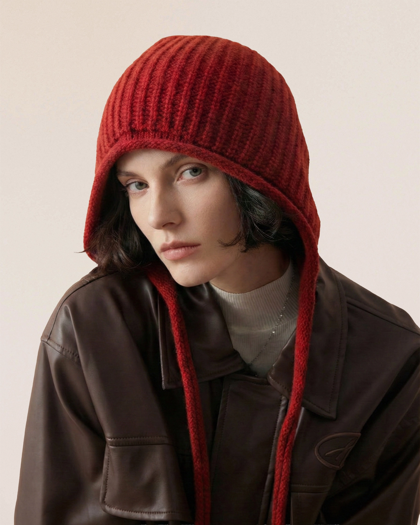 VIONIS·XY merino tie-bonnet in scarlet, front view showing face-framing shape, crafted from 100% 16S merino wool