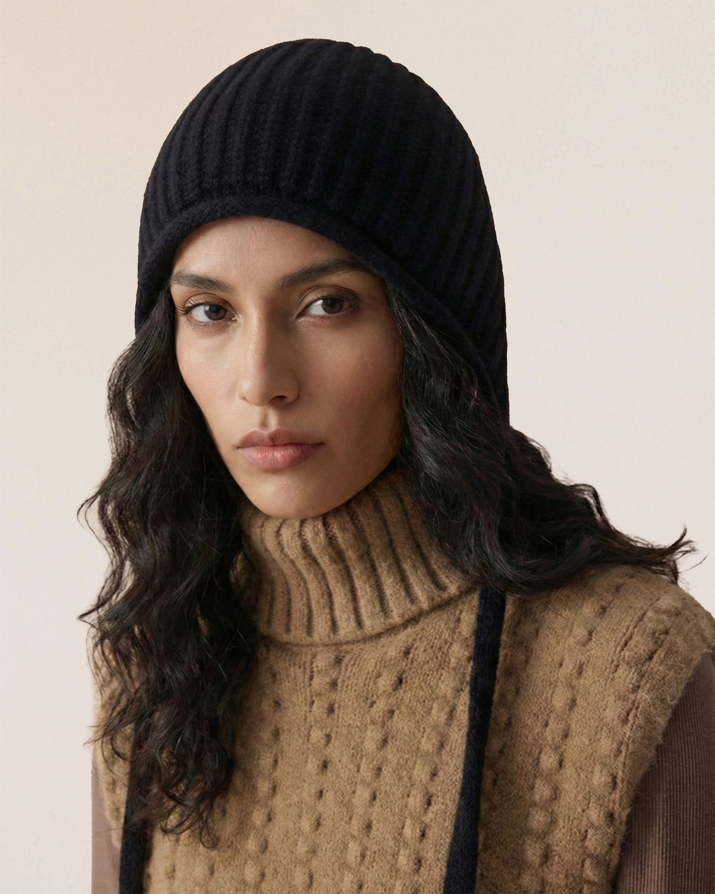 VIONIS·XY merino tie-bonnet in black, front view highlighting minimalist silhouette and face-framing structure