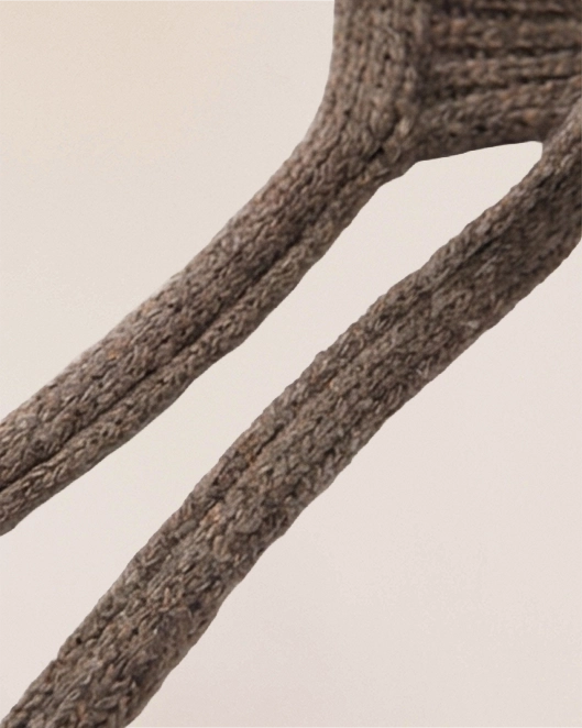 Close-up of VIONIS·XY cocoa merino bonnet ties, elongated soft knit for adjustable styling