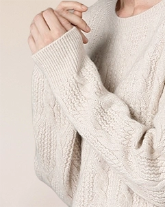 Close-up of VIONIS·XY ivory white cashmere sweater sleeve, ribbed cuff and soft cable knit texture